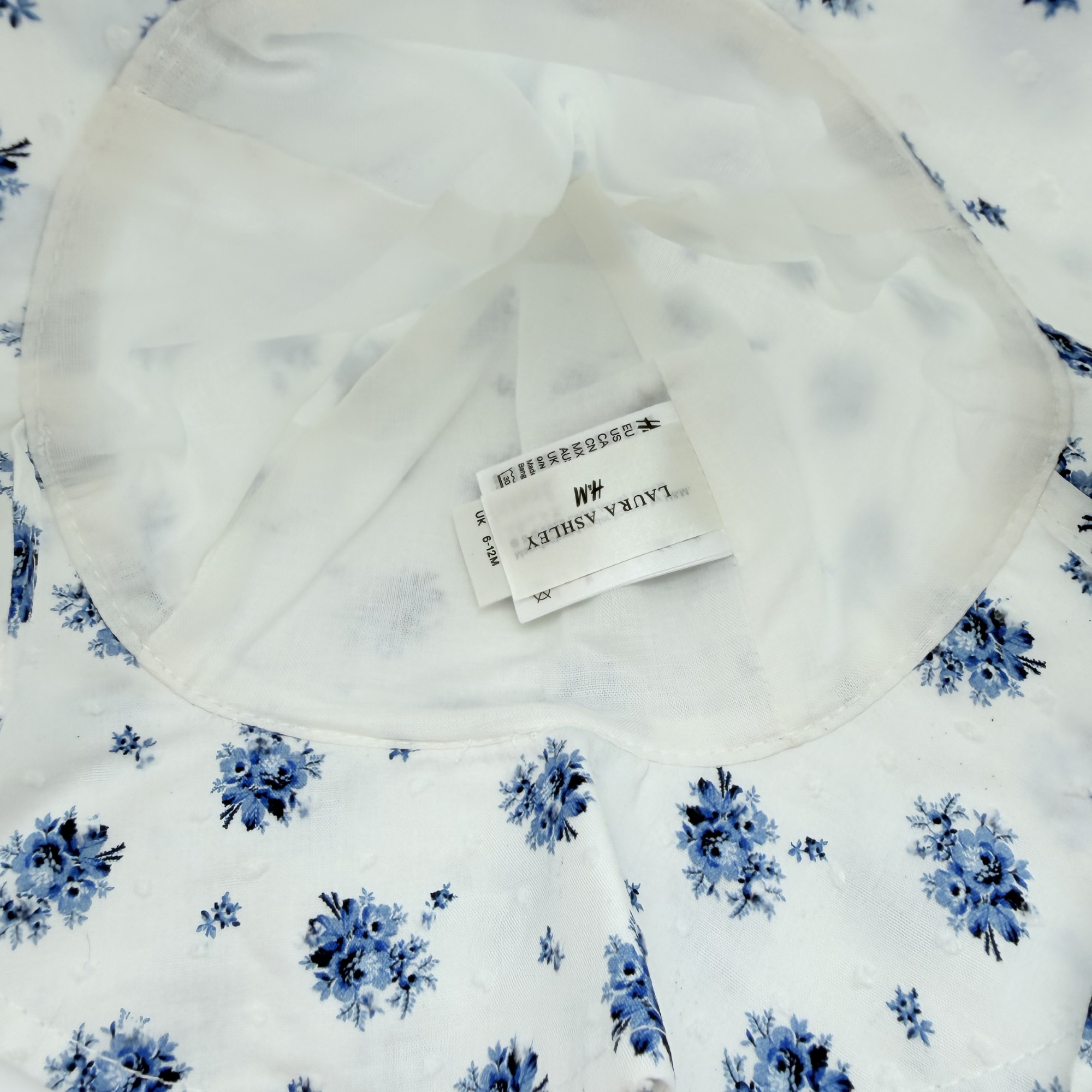 Chapeau blanc à fleurs bleues – 6-12 mois